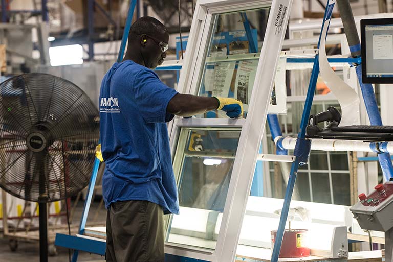 Champion employee working on final assembly of window