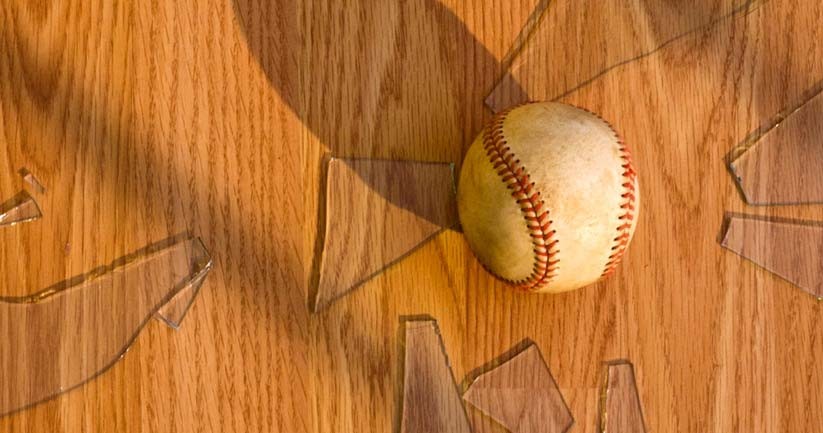 Baseball laying on the floor with broken glass