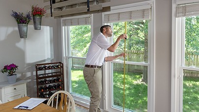 Champion installation technician taking a window measurement