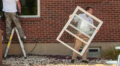 Champion installer removing old window frame from home