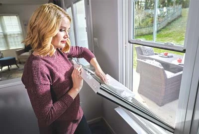 Person spraying on Champion Glass cleaner and wiping with a lint-free cloth