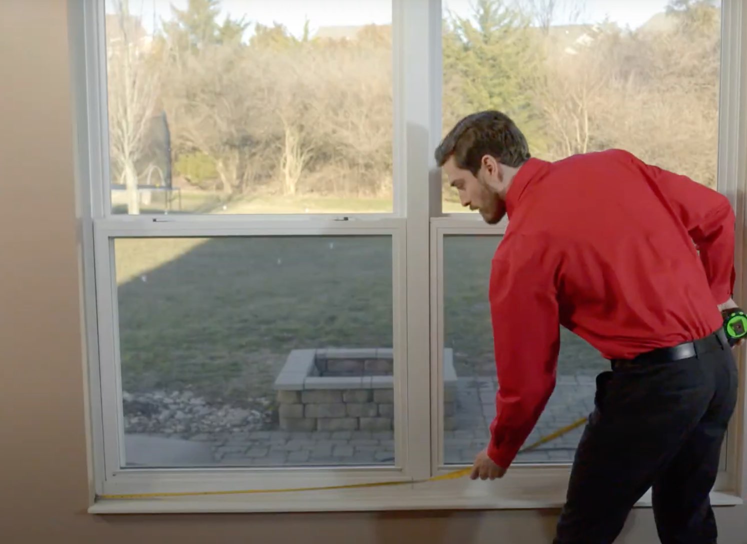 Champion employee measuring window with tape measure